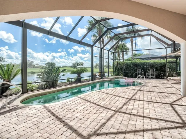 View of pool featuring a patio, an in ground hot tub, a water view, and screened enclosure