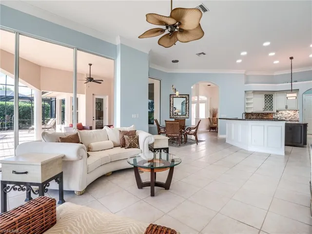 Tiled living room featuring ornamental molding and ceiling fan