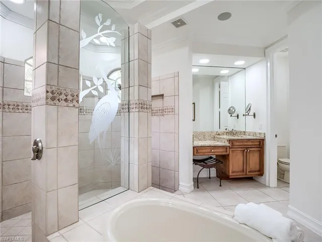 Full bathroom featuring vanity, independent shower and bath, tile patterned flooring, crown molding, and toilet