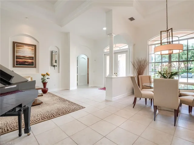 Dining room featuring decorative columns, ornamental molding, light tile patterned floors, and a wealth of natural light
