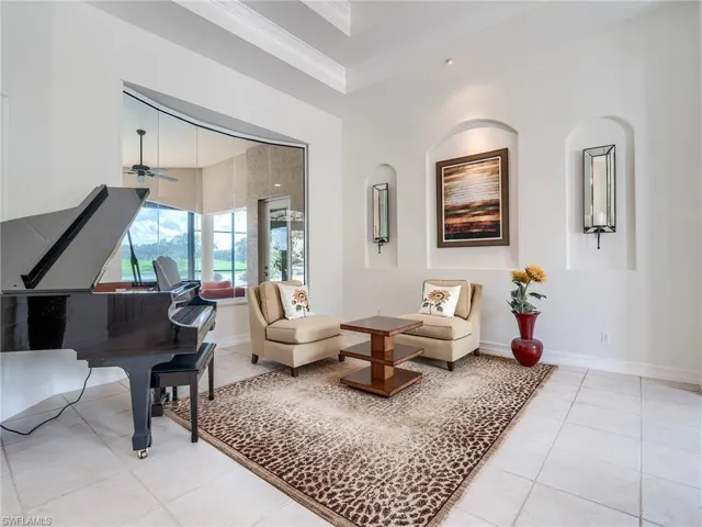 Living area featuring ceiling fan, crown molding, and light tile patterned floors