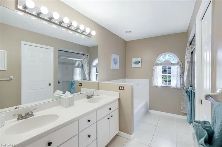 Bathroom featuring a shower stall, a sink, a bath, and tile patterned floors