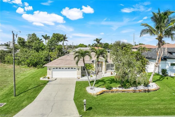 View of front of home featuring an attached garage, stucco siding, concrete driveway, and a front yard