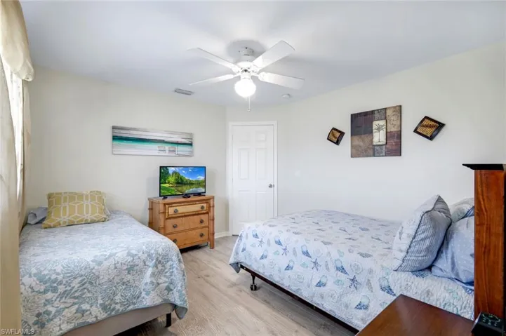 Bedroom featuring light wood finished floors, visible vents, and a ceiling fan