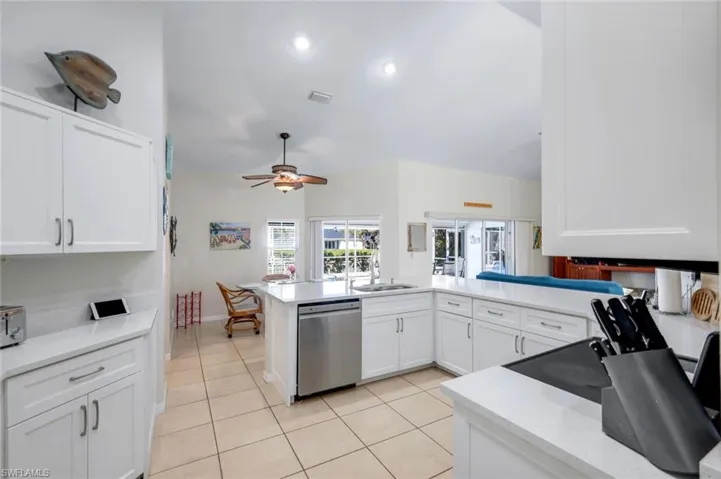 Kitchen with visible vents, white cabinets, a sink, light tile patterned flooring, and dishwasher