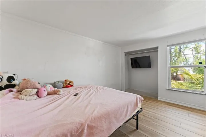 Bedroom featuring light wood-type flooring and ornamental molding