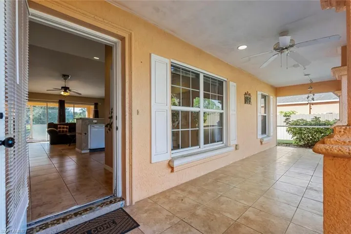 View of exterior entry featuring a patio and ceiling fan