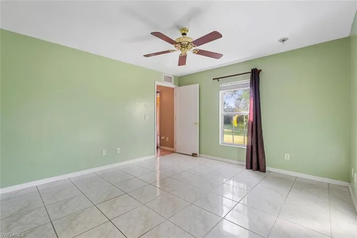 Spare room featuring ceiling fan and light tile patterned flooring