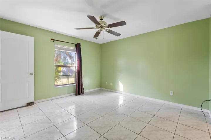 Unfurnished room with ceiling fan and light tile patterned floors