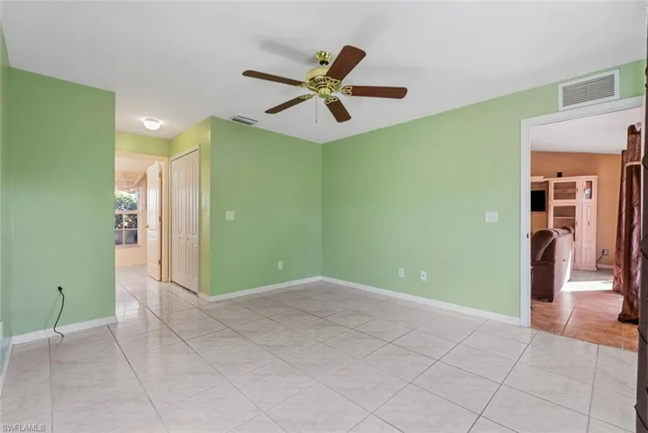 Empty master bedroom with ceiling fan and light tile patterned flooring