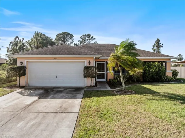 Ranch-style house featuring a 2 car garage and a front lawn