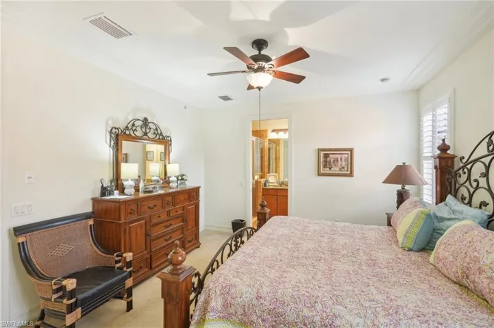 Bedroom featuring light carpet, ceiling fan, visible vents, and crown molding