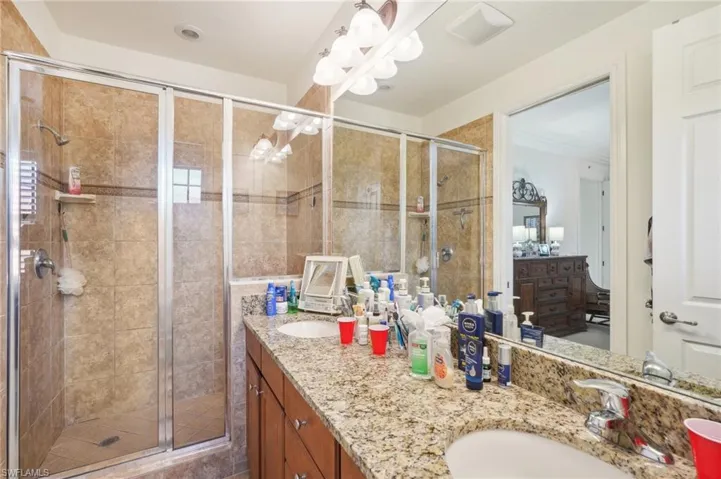 Full bath with a stall shower, a sink, and double vanity