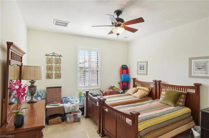 Bedroom with light carpet, ceiling fan, and visible vents