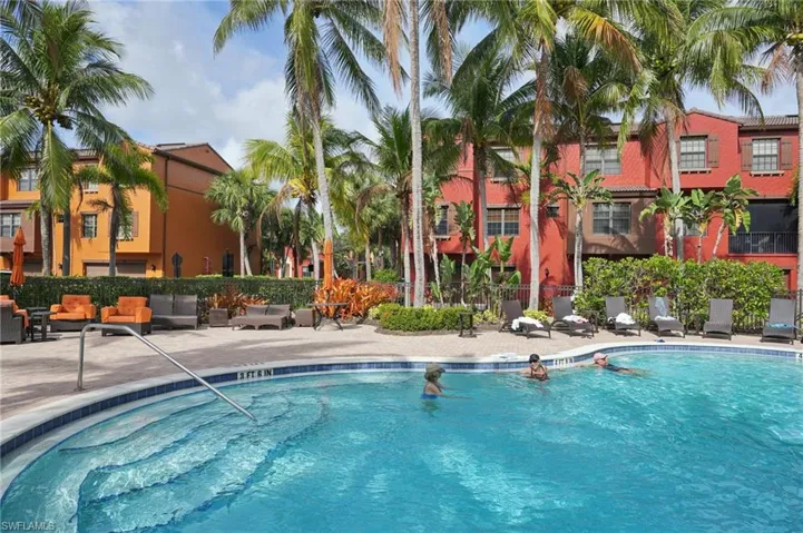 Community pool with a patio area and fence