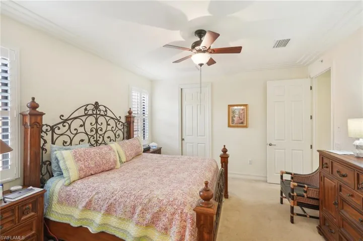 Bedroom featuring light colored carpet, a ceiling fan, baseboards, visible vents, and a closet