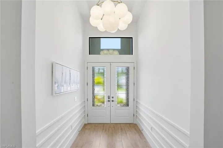 Double entry doors with decorative glass panels and transom window