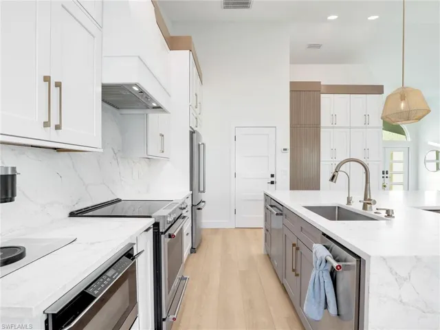 Kitchen featuring pendant lighting, white cabinetry, appliances with stainless steel finishes, and sink