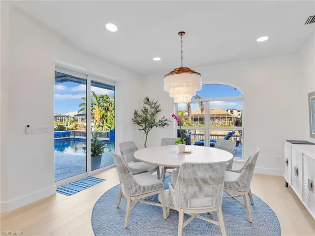 Dining space with light hardwood / wood-style flooring, plenty of natural light, and an inviting chandelier