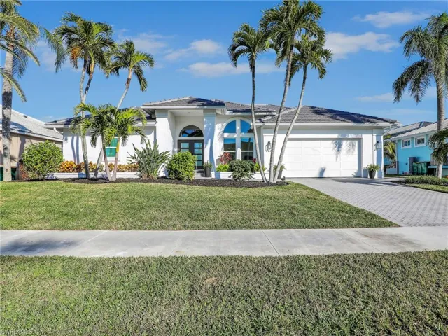 View of front of home featuring french doors, a garage, and a front lawn