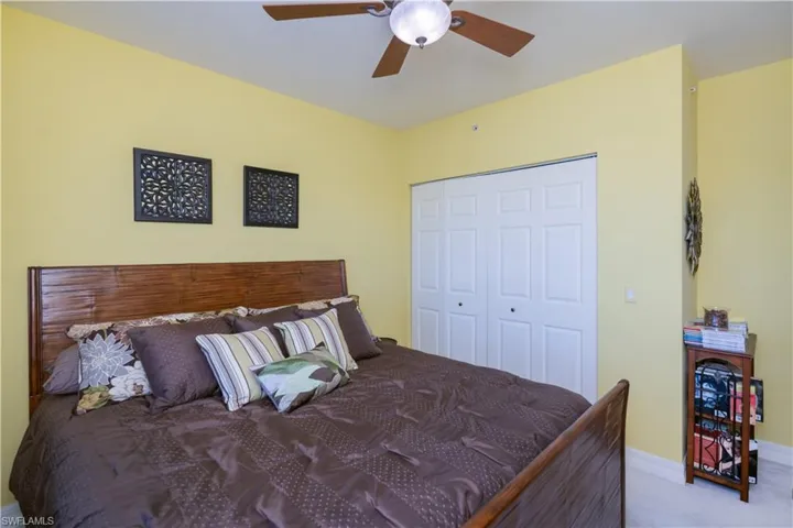 Bedroom featuring a closet, ceiling fan, and light colored carpet