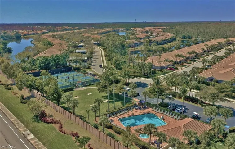 Aerial view of property and surrounding area with a large body of water and a pool area