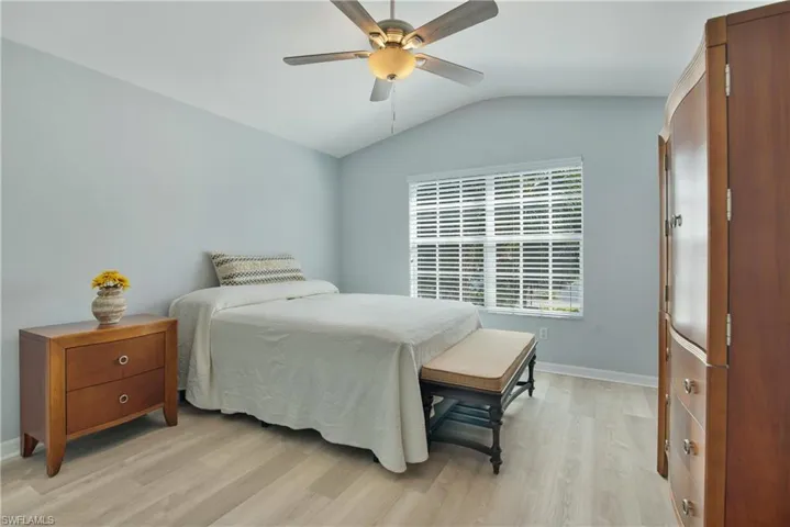 Bedroom with lofted ceiling, light wood-style flooring, and ceiling fan