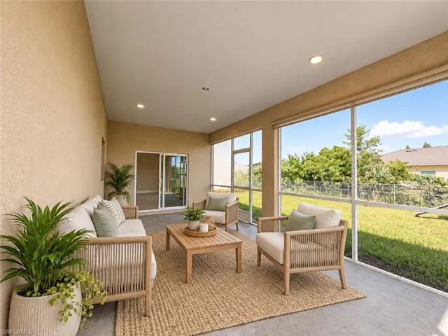 Screened-in outdoor living space with a vaulted ceiling and recessed lighting
