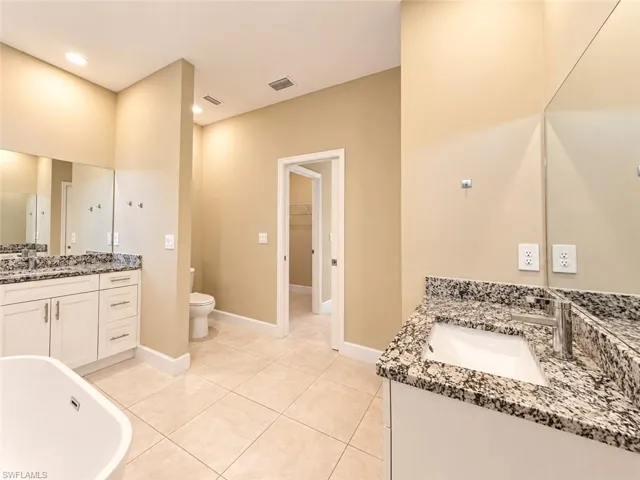 Dual vanity with granite countertops, undermount sinks, and chrome fixtures