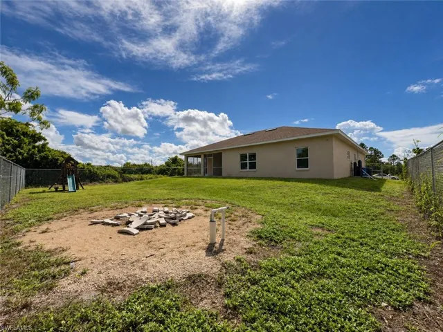 Expansive backyard featuring a screened-in lanai and mature perimeter landscaping