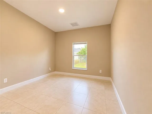 Recessed ceiling lighting, tiled flooring, neutral wall tones, white trim, and a window