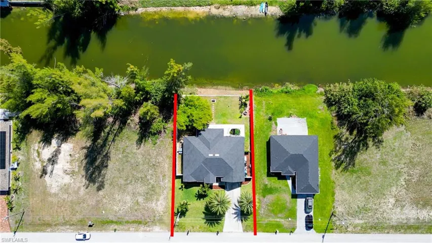 Aerial view of property and surrounding area featuring a large body of water and property boundaries highlighted