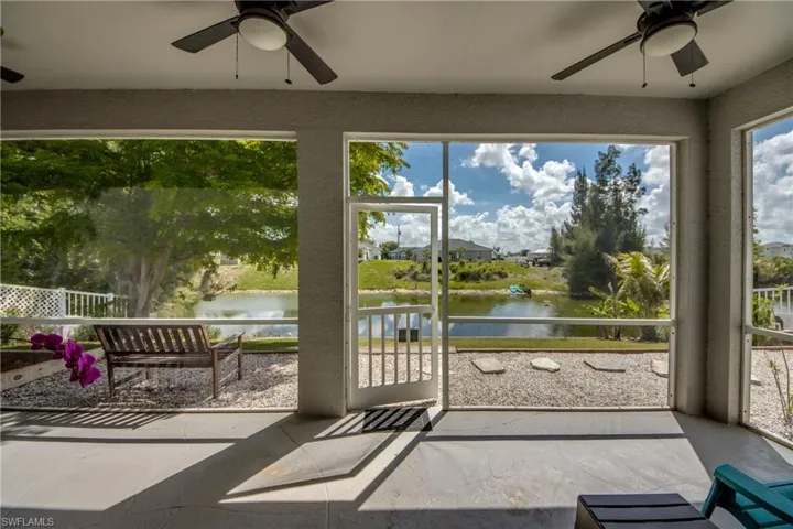 Sunroom with ceiling fan and a water view