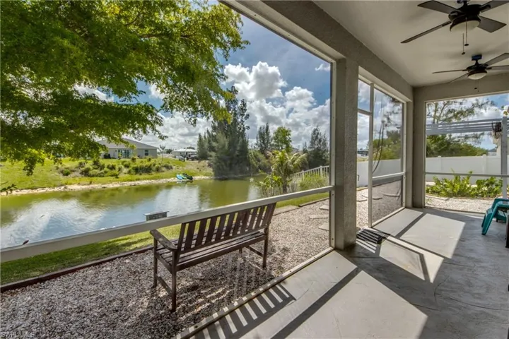 Sunroom with ceiling fan and a water view