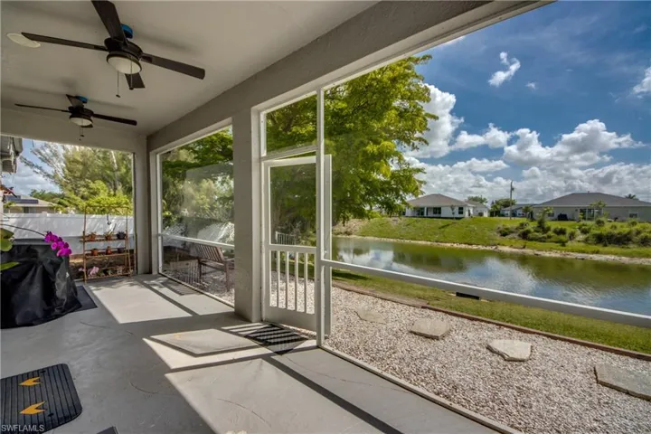 Sunroom with a ceiling fan and a water view
