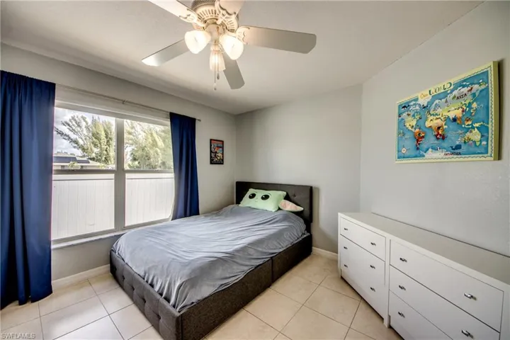Bedroom with a ceiling fan and light tile patterned flooring