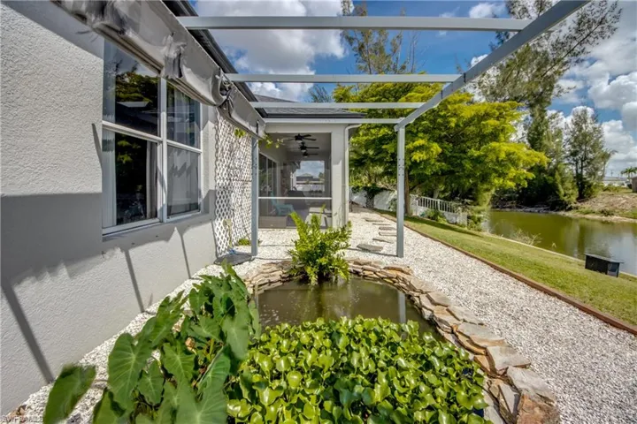 Unfurnished sunroom featuring a patio, a pergola, ceiling fan, and a garden pond