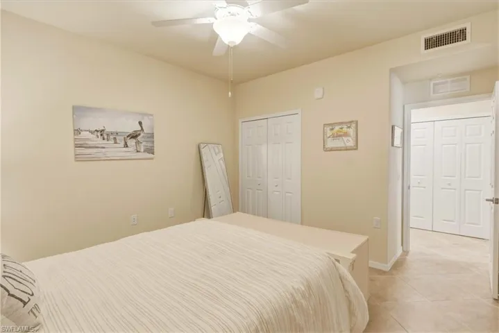 Bedroom with ceiling fan, a closet, and light tile patterned floors