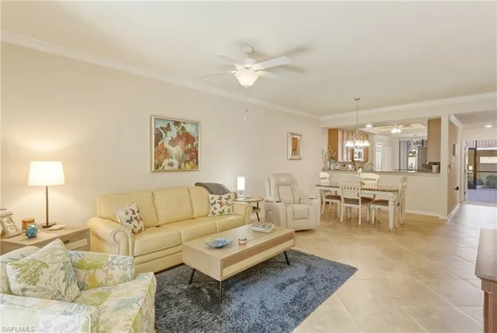 Living area featuring ceiling fan, crown molding, and light tile patterned floors
