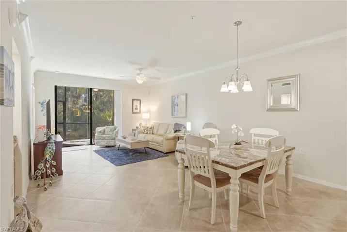 Dining area featuring ceiling fan, crown molding, hanging lights, and light tile patterned floors