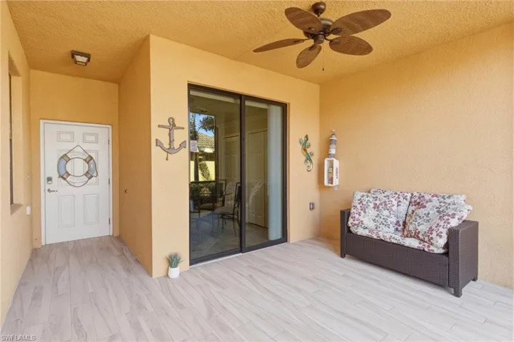 Property entrance featuring ceiling fan and stucco siding