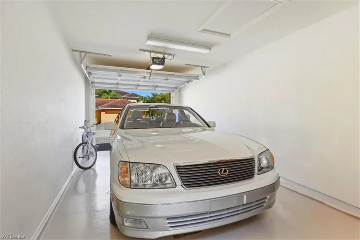 Garage featuring baseboards and a garage door opener