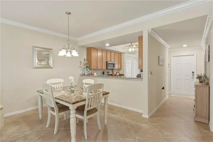 Dining room with ornamental molding, ceiling fan, and a chandelier