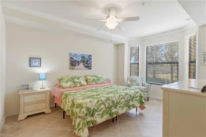 Bedroom featuring crown molding, light tile patterned flooring, and ceiling fan