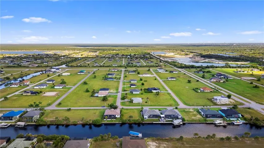 Aerial perspective of suburban area featuring a nearby body of water