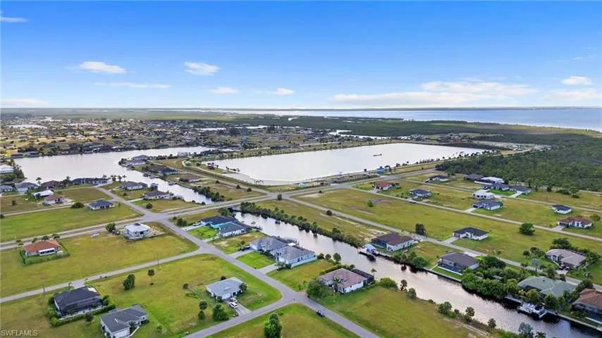 Aerial overview of property's location featuring a large body of water and nearby suburban area