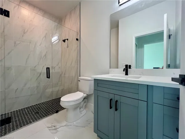 Bathroom with walk in shower, vanity, and toilet