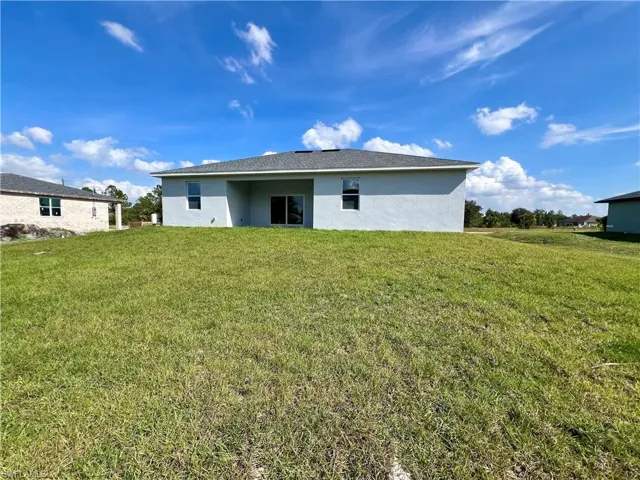 Back of house with a yard