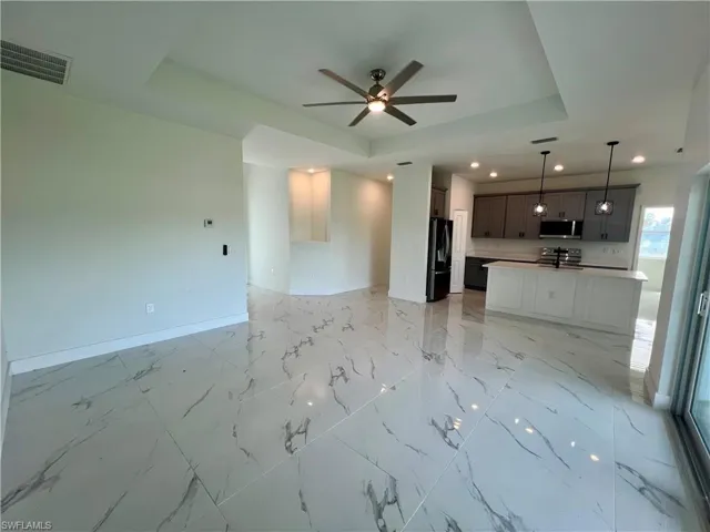 Living room with a tray ceiling and ceiling fan