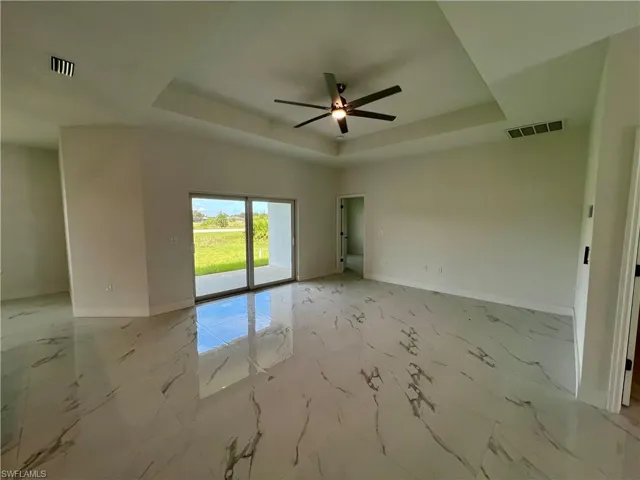 Living room featuring a tray ceiling and ceiling fan